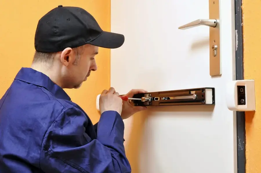 Technicien réparant la gâche d'une fermeture