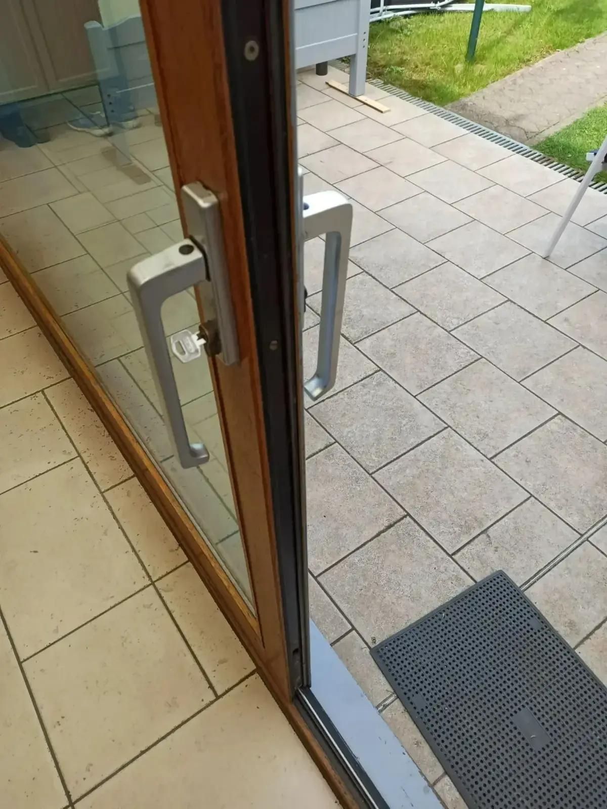 Porte coulissante vitrée entrouverte sur une terrasse