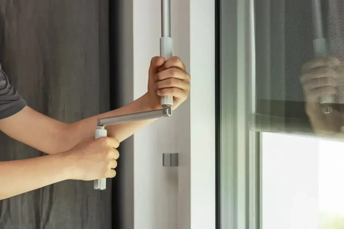Mains tirant la poignée d'une porte coulissante qui résiste