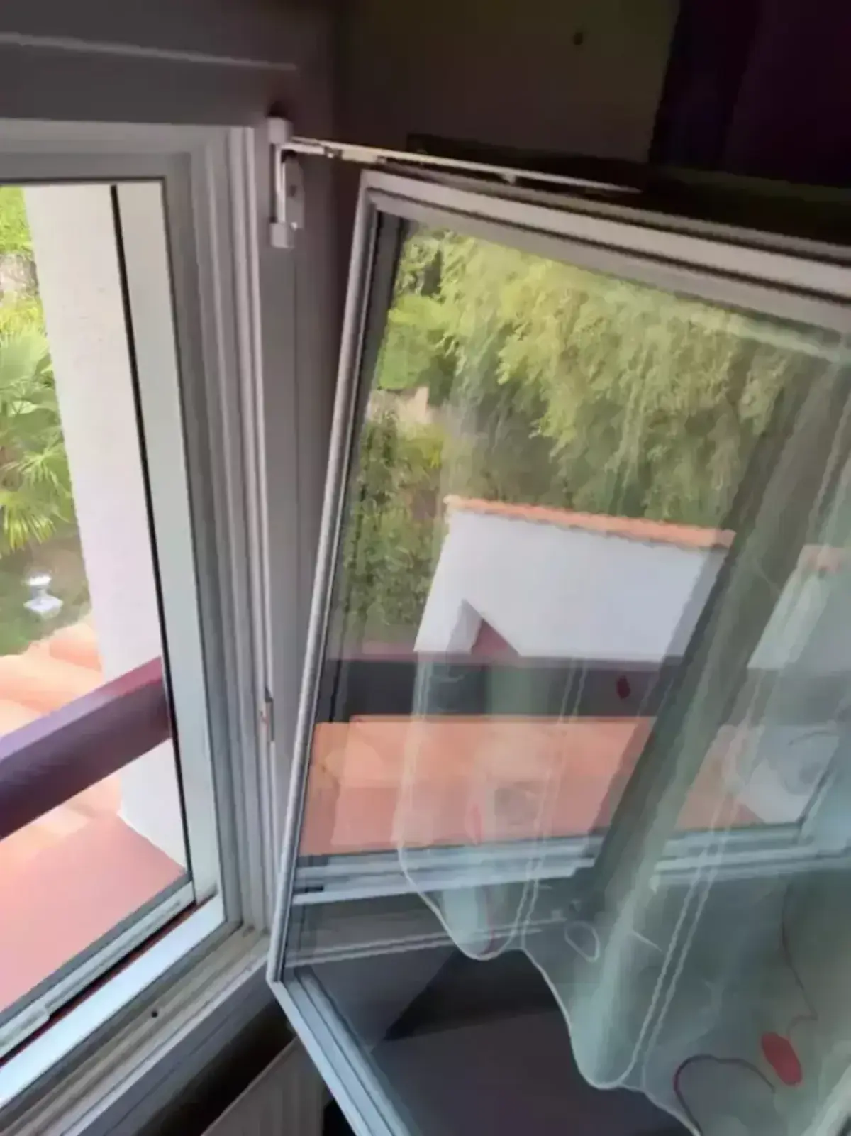 Châssis PVC blanc ouvert sur la verdure